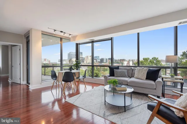 a living room with furniture wooden floor and a large window
