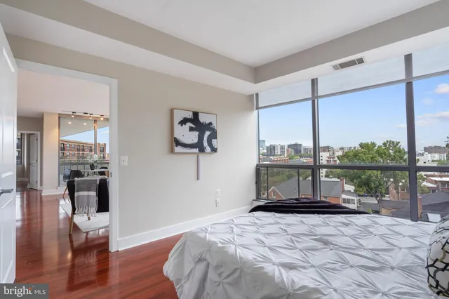 a bedroom with a bed a table and wooden floor