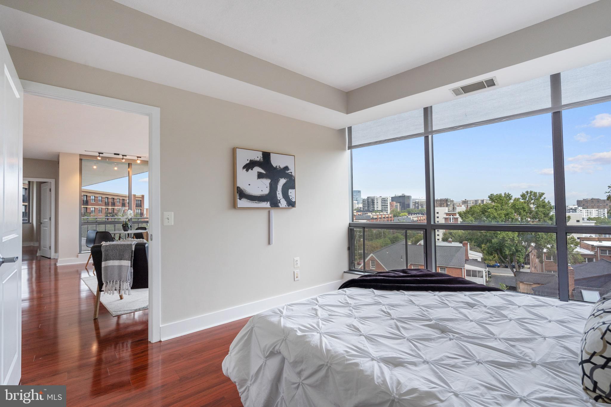 2001 15th Street North, Unit 306 Arlington, VA 22201 - Photo 23 of 54 a bedroom with a bed a table and wooden floor