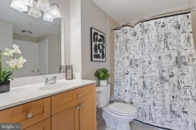 a bathroom with a granite countertop sink a toilet and a mirror