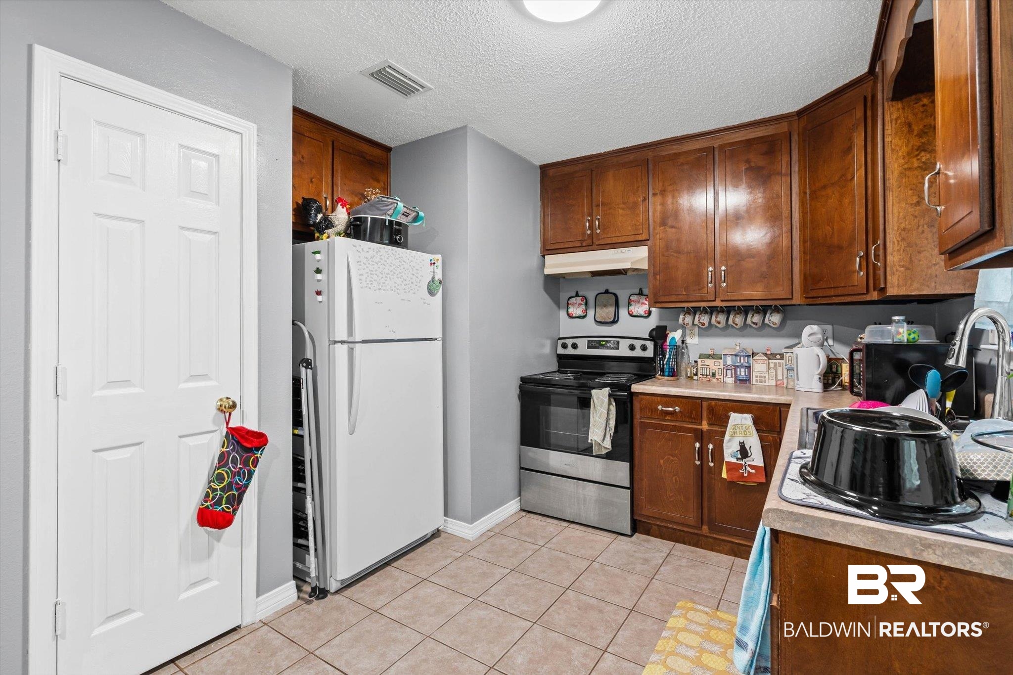 14165 River Oaks Road, Unit A & B Coden, AL 36523 - Photo 17 of 35 Kitchen featuring stainless steel electric range oven, freestanding refrigerator, light countertops, a textured ceiling, and light tile patterned floors
