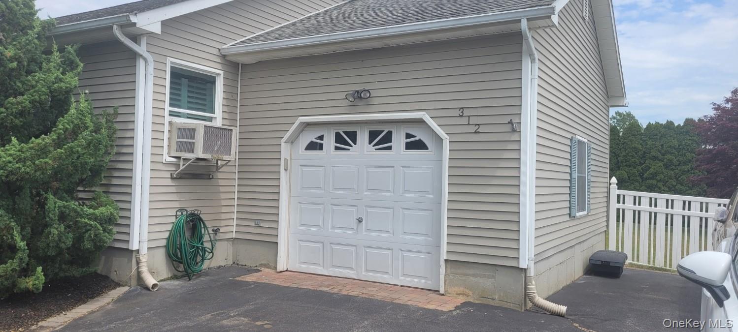 312 Riley Avenue Calverton, NY 11933 - Photo 3 of 30 Single-car garage with arched decorative windows and exterior lighting