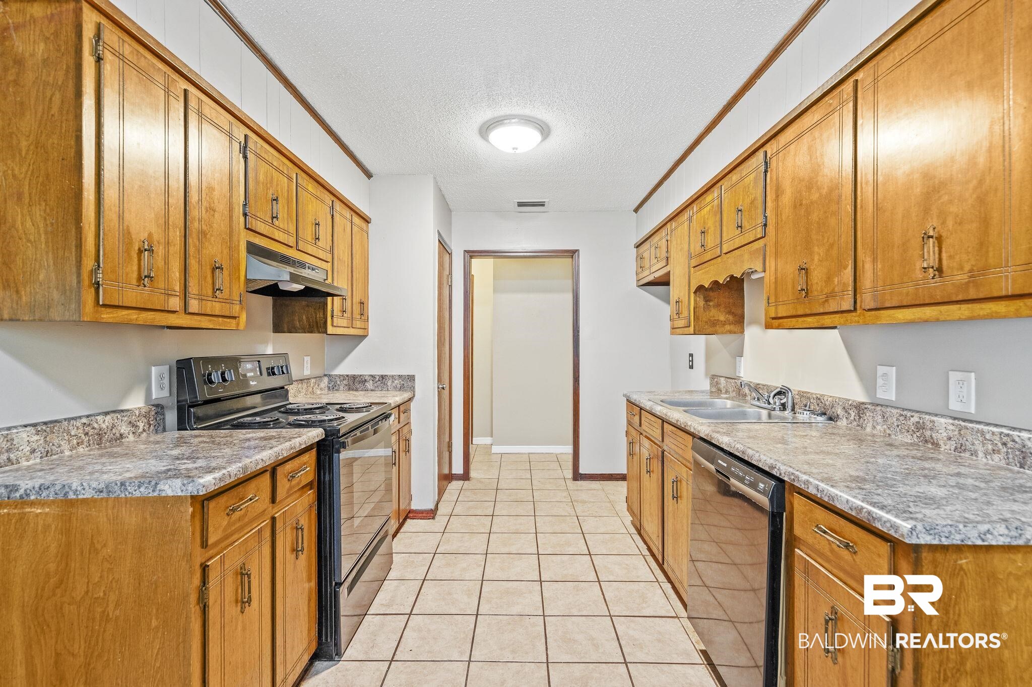 4151 Springdale Road Mobile, AL 36609 - Photo 14 of 21 Kitchen with a textured ceiling, light tile patterned flooring, sink, black appliances, and ornamental molding