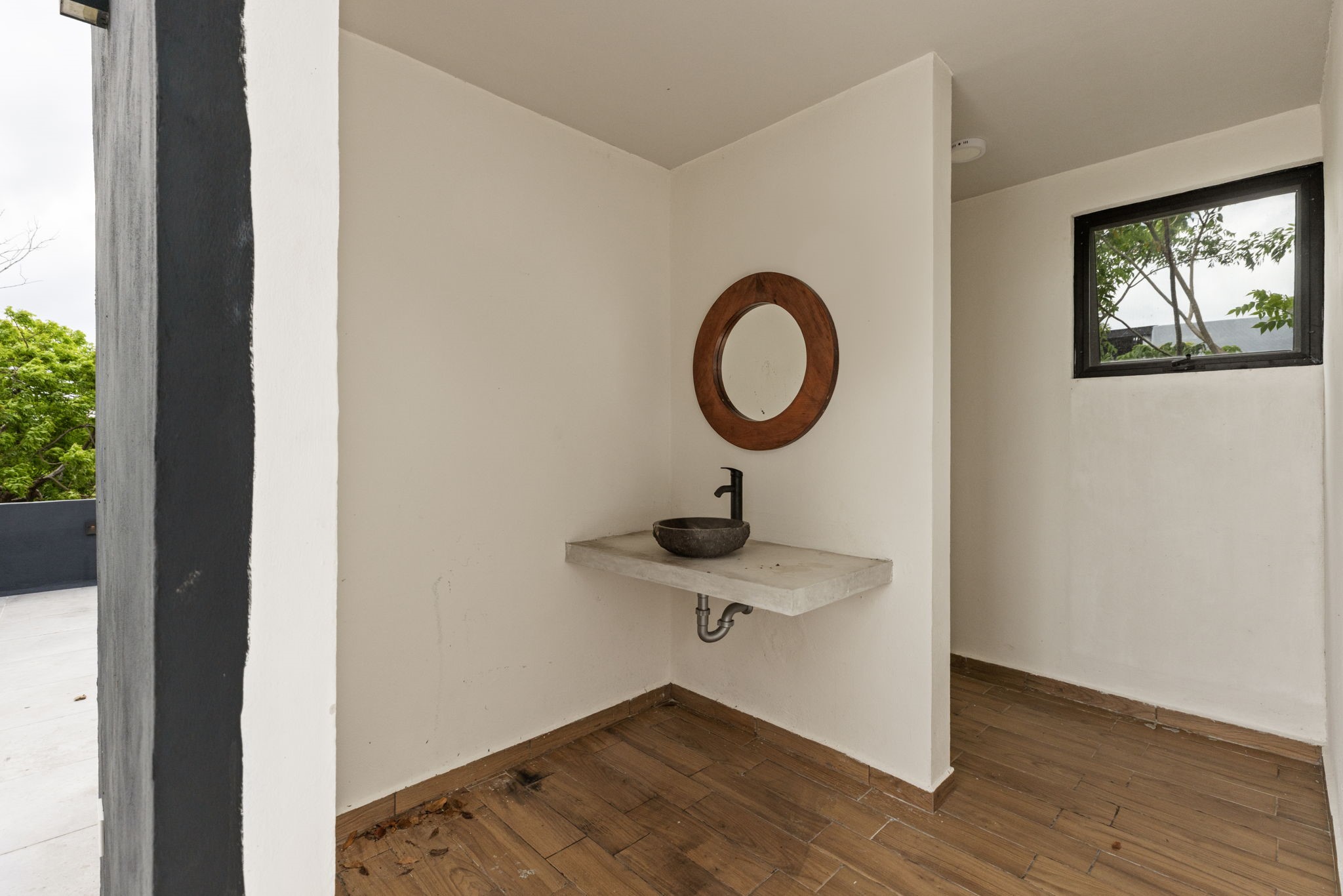 6 Country Club, Unit 4 Nome, TX 77629 - Photo 29 of 45 This minimalist rooftop half-bath offers exceptional convenience for outdoor guests while perfectly matching the home's signature contemporary aesthetic and organic design palette. Designed for effortless entertaining, the open-entry privacy wall layout keeps the space feeling bright and airy while providing direct access from the open-air terrace.