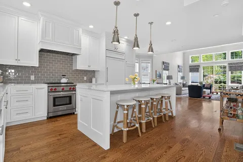 a kitchen with stainless steel appliances a stove a sink a oven a dining table and chairs