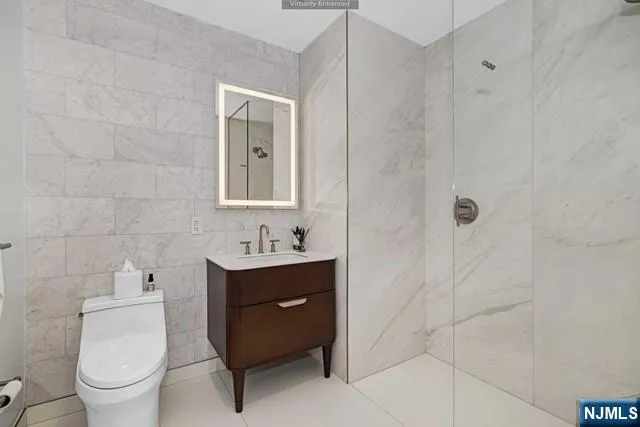 a bathroom with a toilet sink vanity and mirror