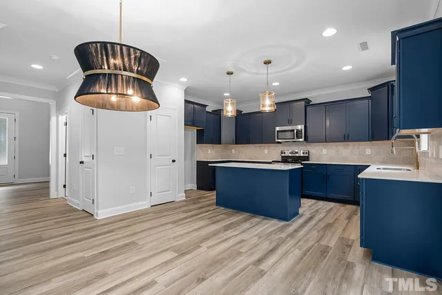 a hallway with white doors wooden floor and front door