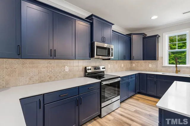 a large kitchen with kitchen island a large counter space a sink appliances and cabinets