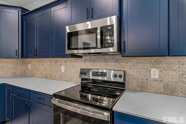 a view of a livingroom with a fireplace a ceiling fan and wooden floor