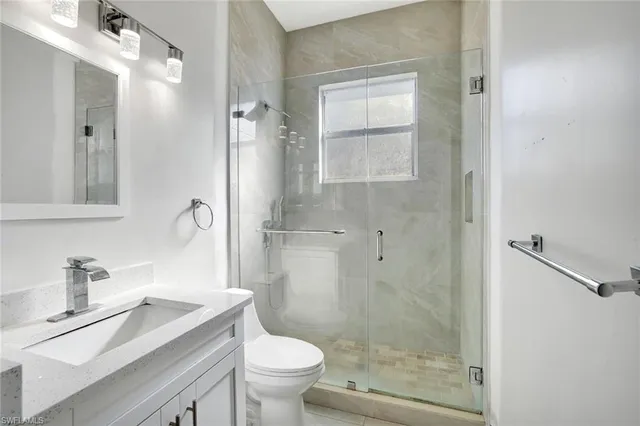 a bathroom with a sink a toilet and shower