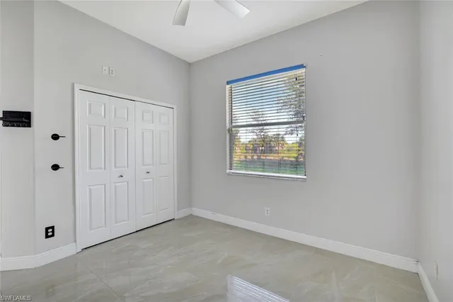a view of an empty room with window and closet area