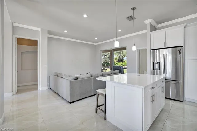 a living room with white cabinets and refrigerator