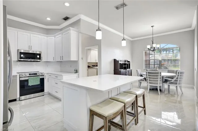 a large kitchen with kitchen island a dining table chairs and a wooden floor