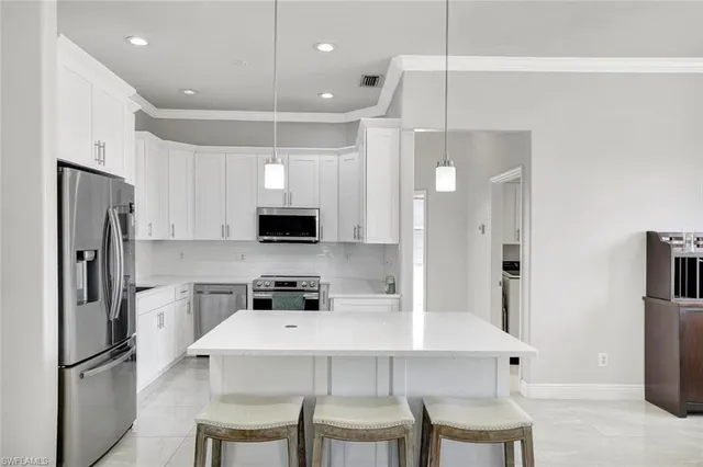 a kitchen with stainless steel appliances a refrigerator sink and microwave