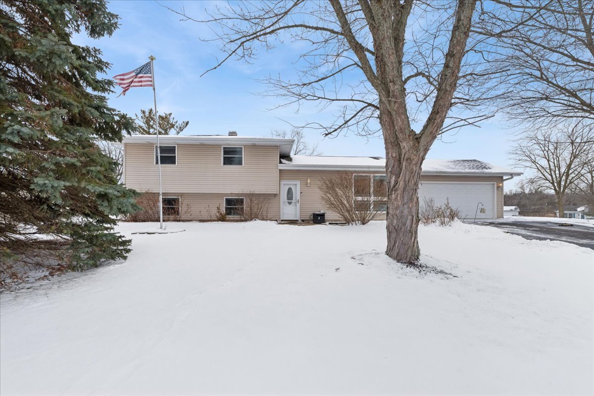 a view of a house with a yard covered in snow
