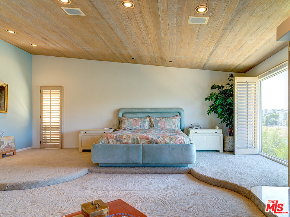 4611 Roma Court Marina del Rey, CA 90292 - Photo 15 of 26 a bedroom with a large bed and a potted plant