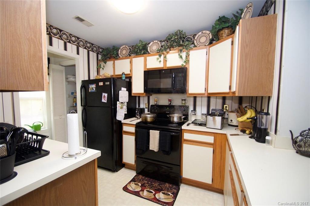 6728 Bevington Ridge Road Charlotte, NC 28277 - Photo 7 of 8 a kitchen with a refrigerator a stove a sink a counter space and a window