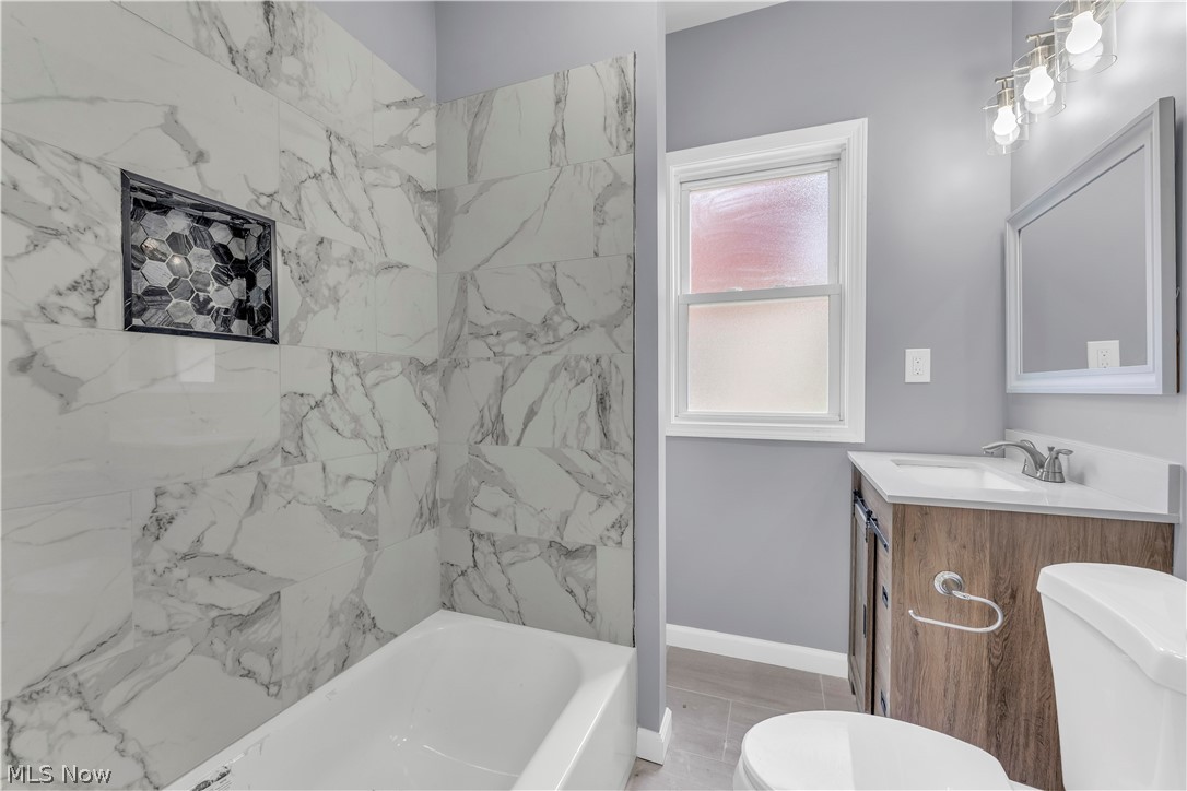 3925 Riverside Avenue Cleveland, OH 44109 - Photo 17 of 46 Bathtub with large format marble-look tile surround and mosaic tile niche