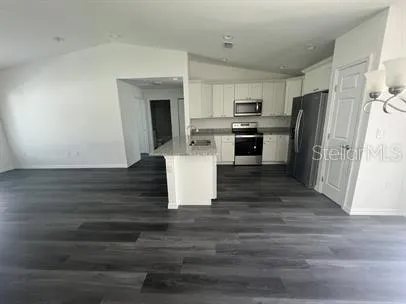 a view of kitchen with wooden floor and electronic appliances