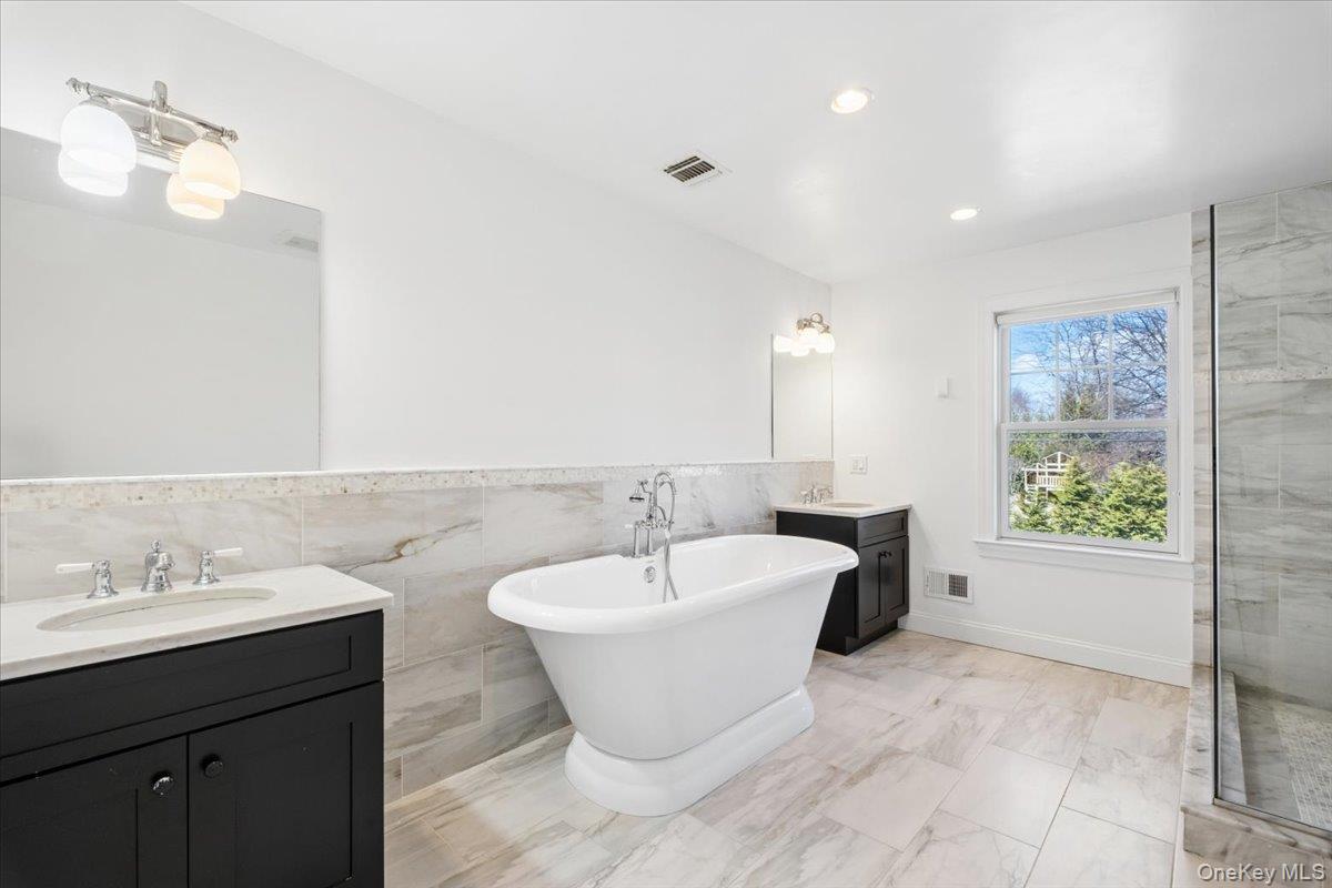 73 Atherstone Road Scarsdale, NY 10583 - Photo 16 of 34 a spacious bathroom with a bathtub and a sink