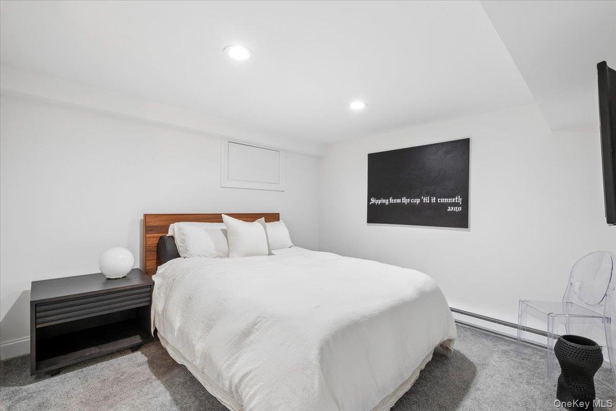 73 Atherstone Road Scarsdale, NY 10583 - Photo 23 of 34 a bedroom with a bed and a wall painting