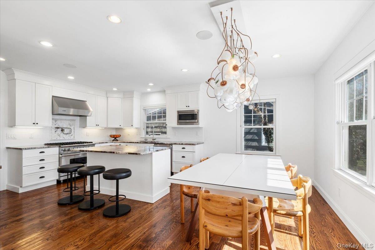 73 Atherstone Road Scarsdale, NY 10583 - Photo 6 of 34 a open kitchen with a refrigerator a stove top oven a sink dishwasher and white cabinets with wooden floor