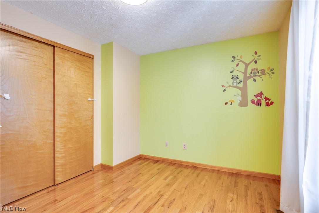 5303 Laubert Road Atwater, OH 44201 - Photo 20 of 37 Unfurnished bedroom featuring light hardwood / wood-style flooring, a closet, and a textured ceiling