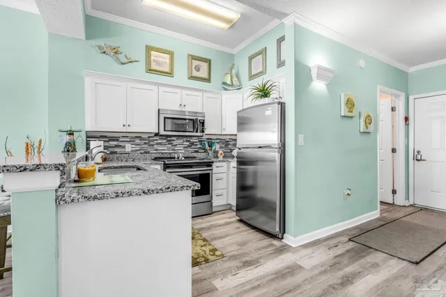 a kitchen with stainless steel appliances granite countertop a refrigerator a stove and a sink