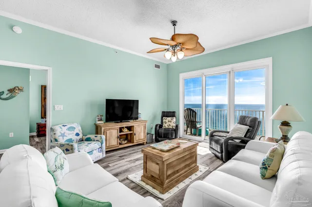 a living room with furniture a floor to ceiling window and a flat screen tv