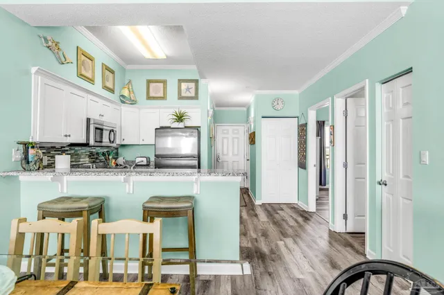 a kitchen with furniture a refrigerator and chairs