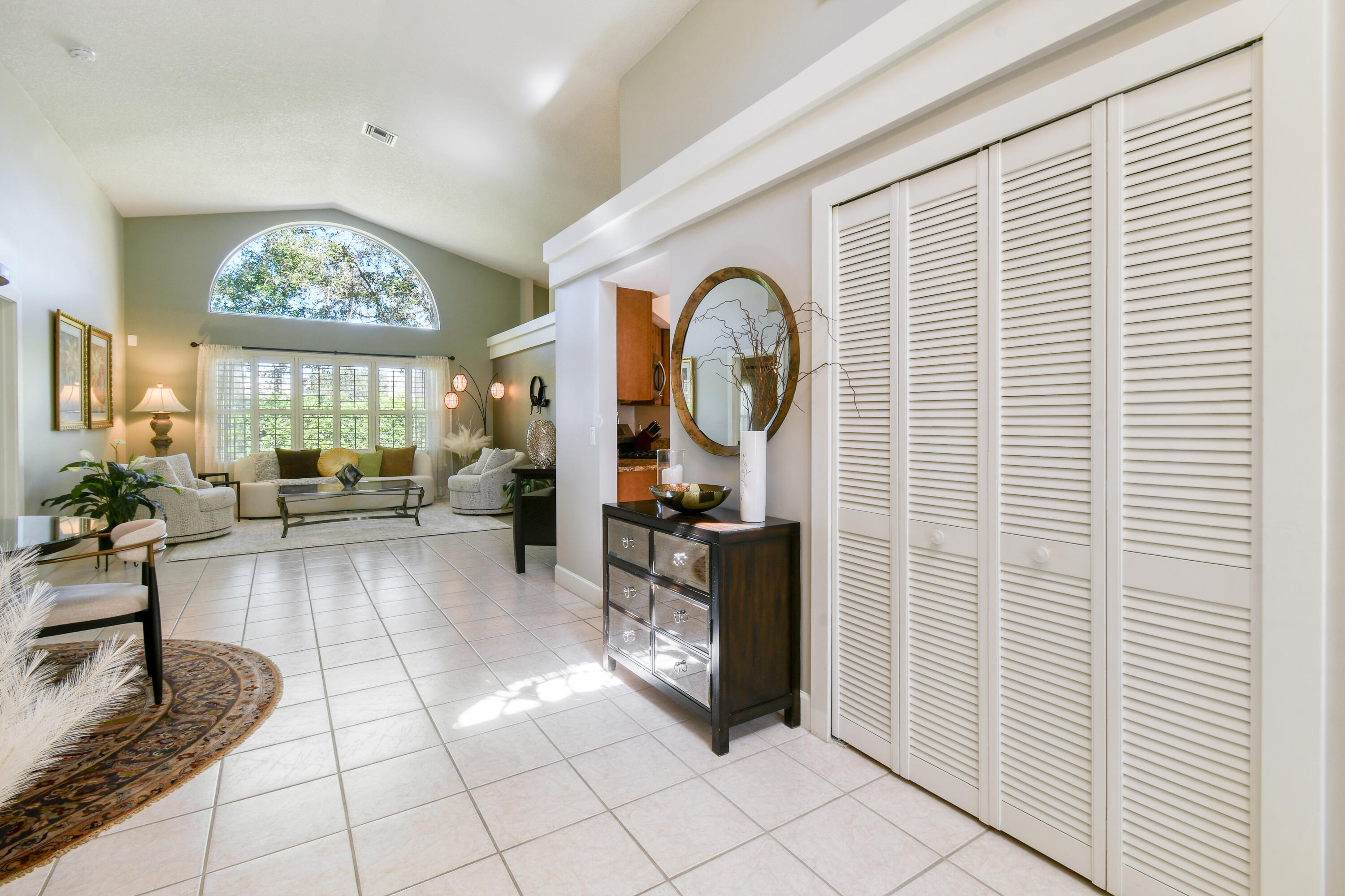 163 Spoonbill Court Jupiter, FL 33458 - Photo 11 of 67 a living room with furniture a chandelier and a large window