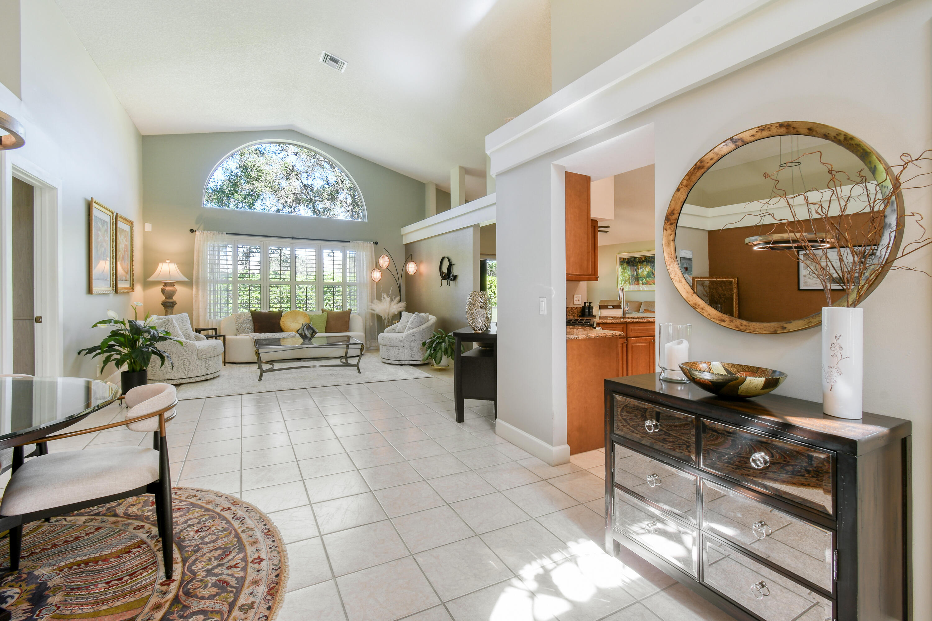 163 Spoonbill Court Jupiter, FL 33458 - Photo 15 of 67 a living room with furniture a mirror and a chandelier