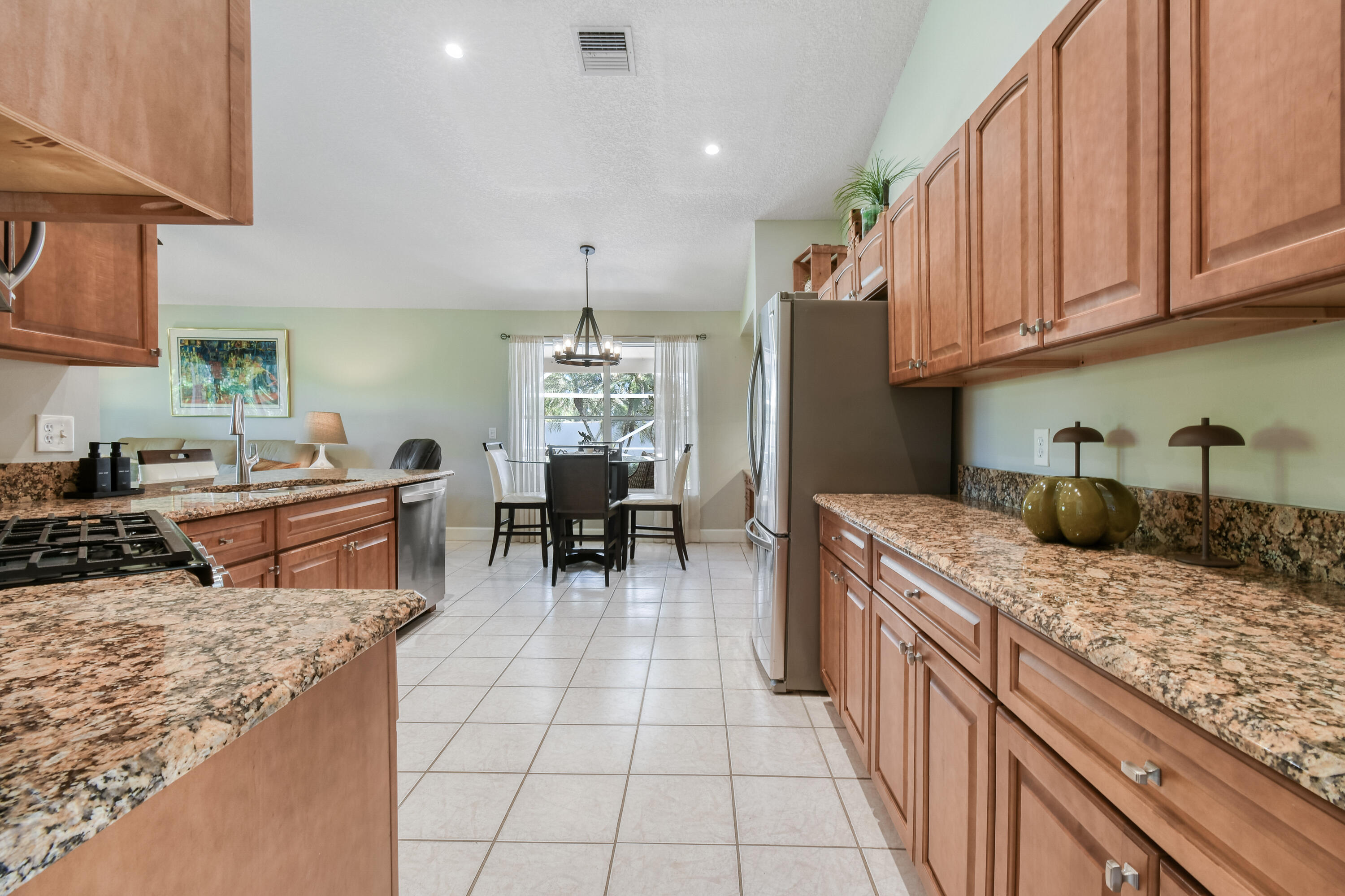 163 Spoonbill Court Jupiter, FL 33458 - Photo 17 of 67 a kitchen with stainless steel appliances granite countertop a sink dishwasher stove and cabinets