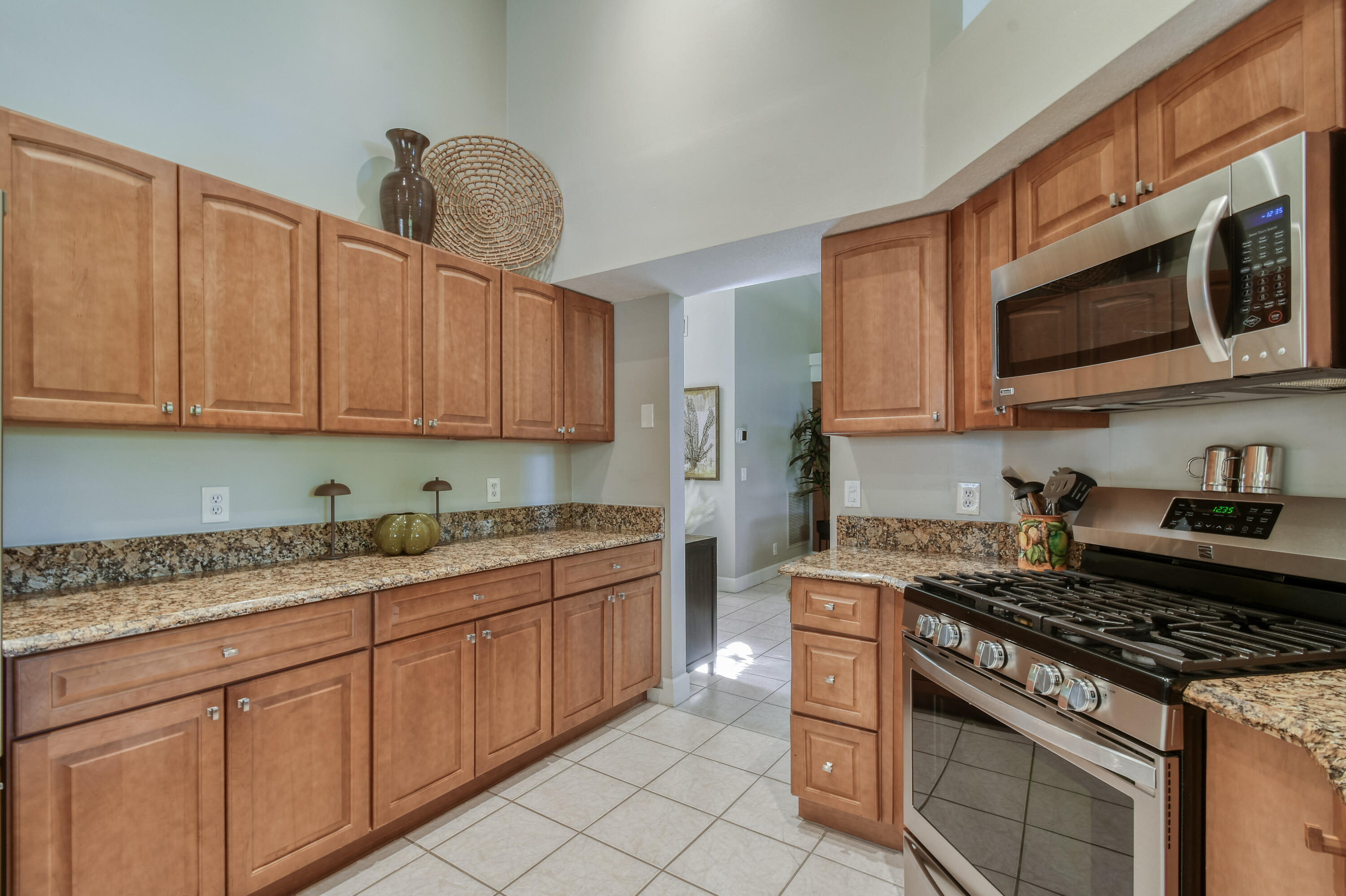 163 Spoonbill Court Jupiter, FL 33458 - Photo 18 of 67 a kitchen with stainless steel appliances granite countertop a stove and a microwave