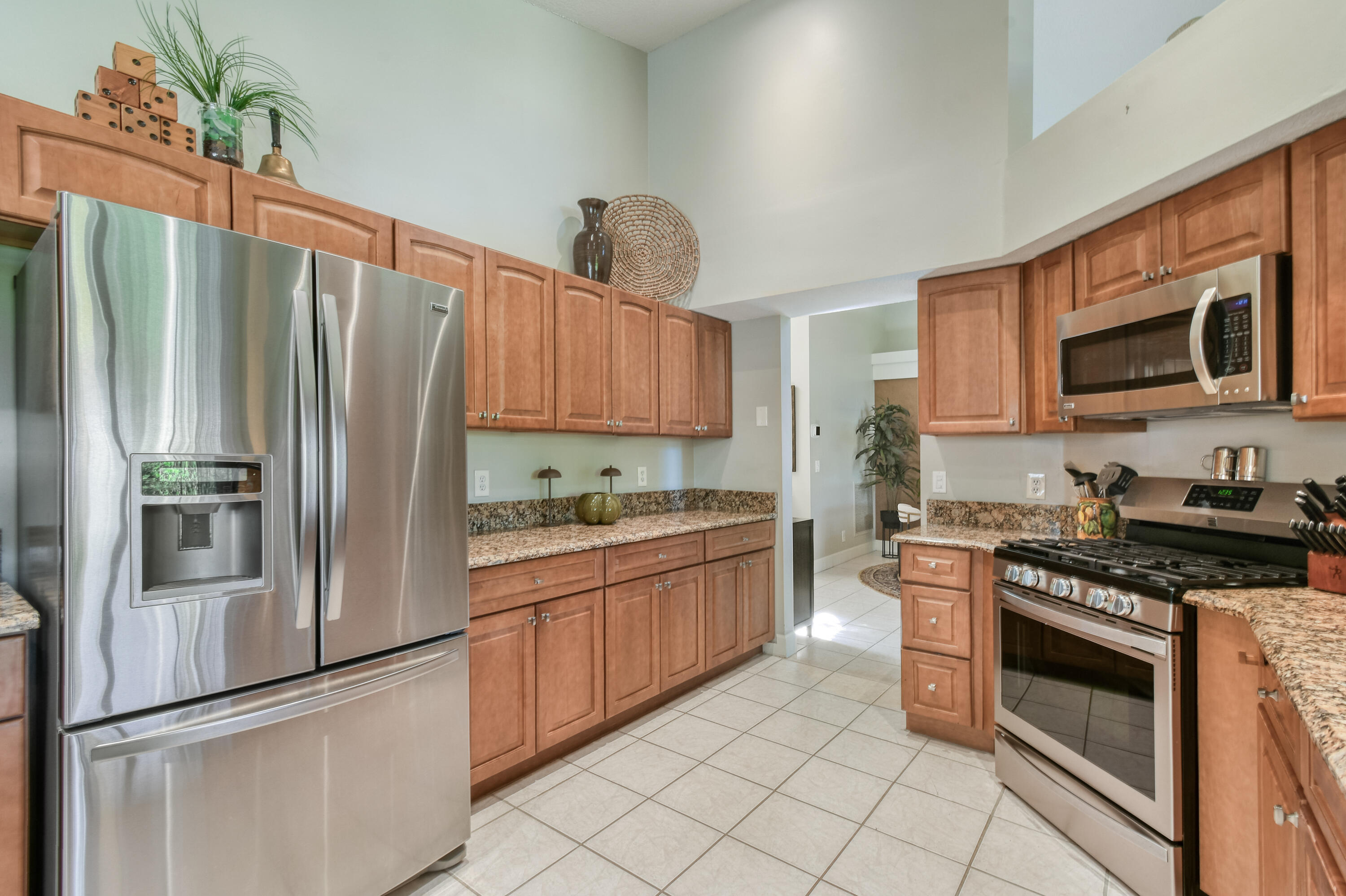 163 Spoonbill Court Jupiter, FL 33458 - Photo 19 of 67 a kitchen with granite countertop a refrigerator stove and microwave
