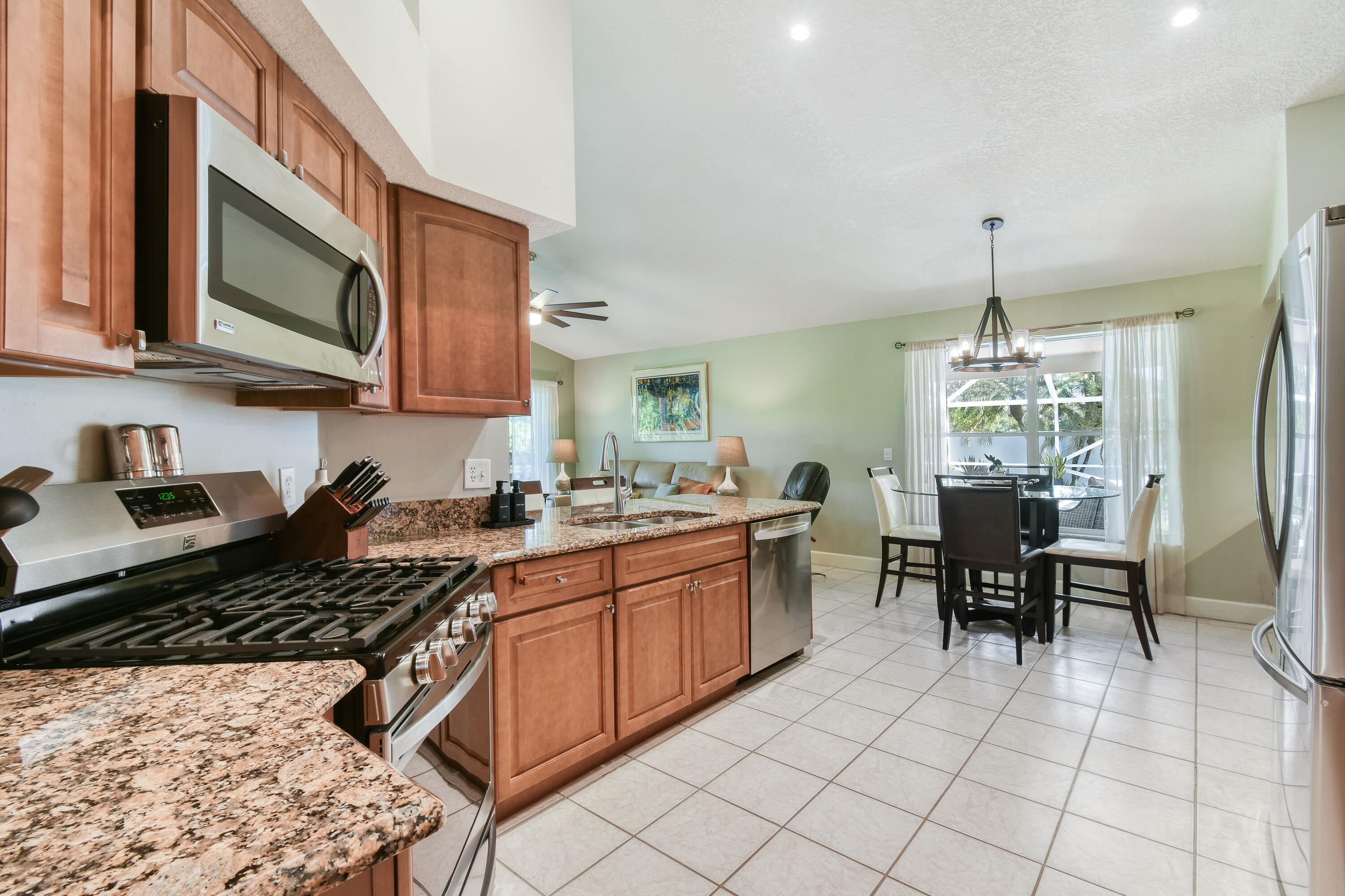 163 Spoonbill Court Jupiter, FL 33458 - Photo 20 of 67 a kitchen with granite countertop a sink stove and cabinets