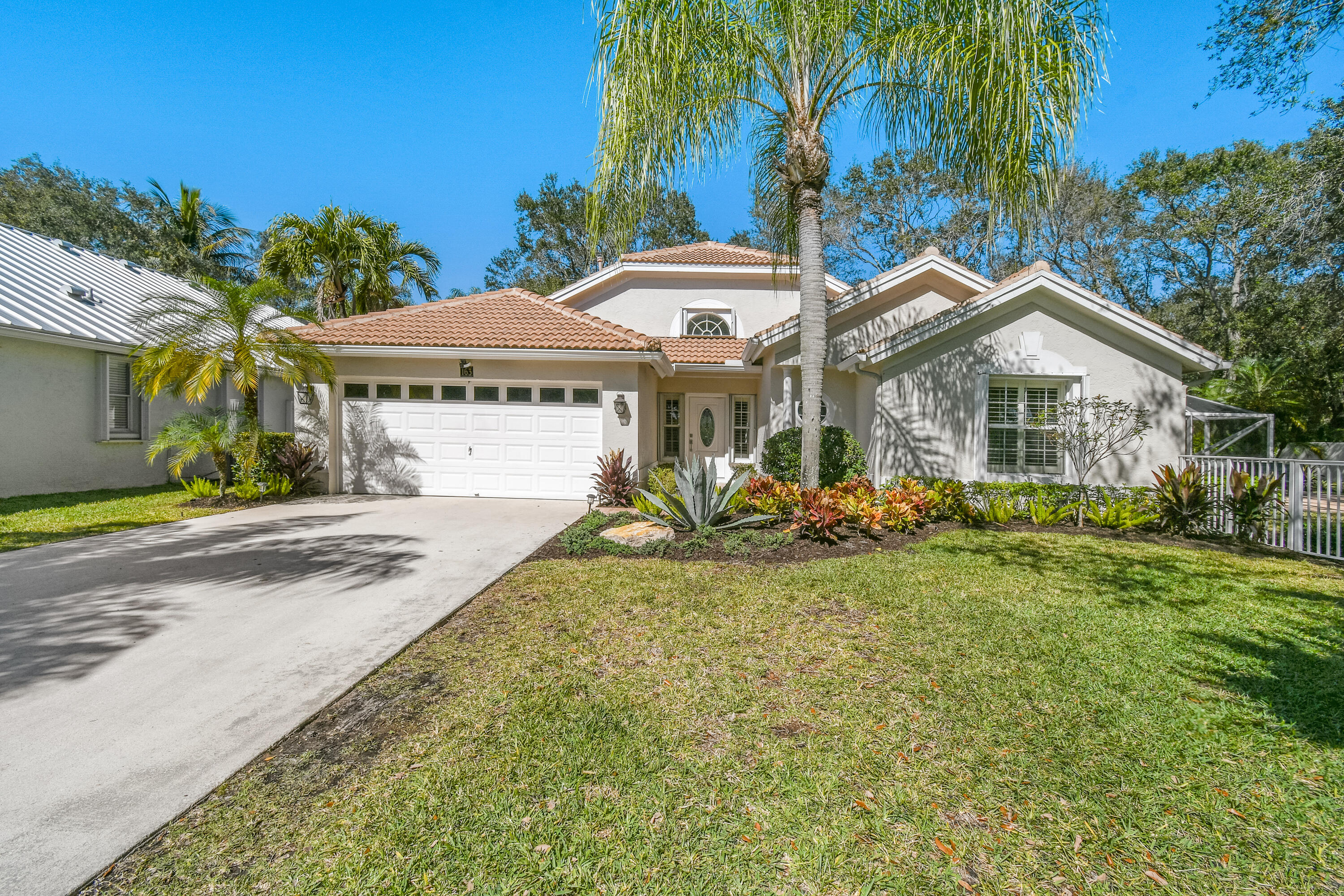 163 Spoonbill Court Jupiter, FL 33458 - Photo 2 of 67 a front view of a house with garden