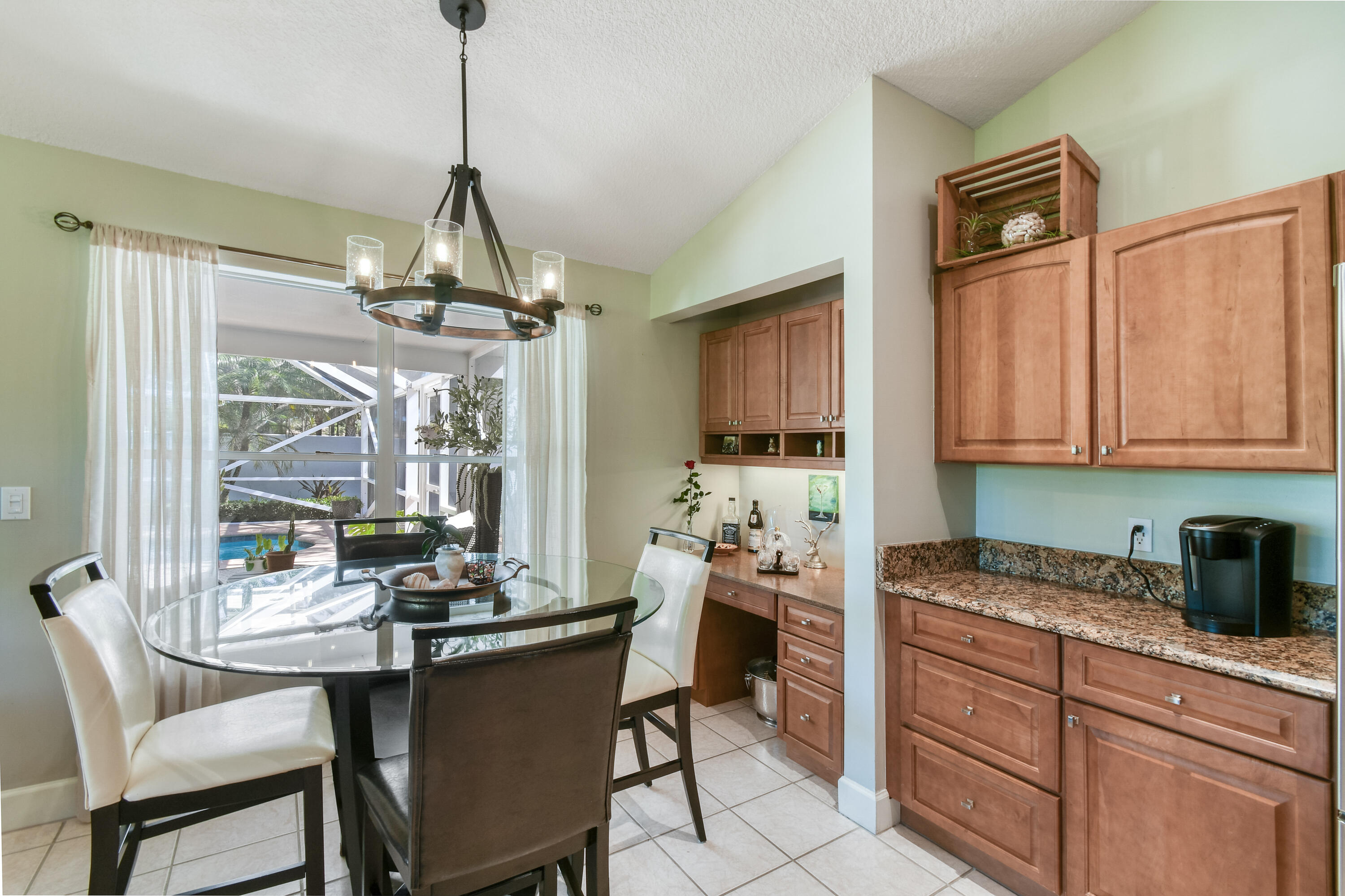 163 Spoonbill Court Jupiter, FL 33458 - Photo 22 of 67 a kitchen with stainless steel appliances granite countertop a stove a sink dishwasher a dining table and chairs with wooden floor