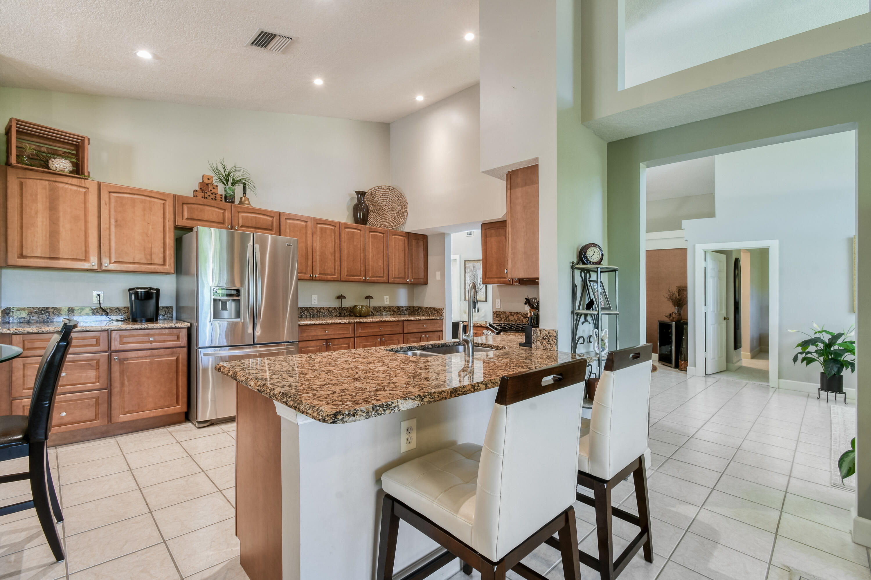 163 Spoonbill Court Jupiter, FL 33458 - Photo 24 of 67 a kitchen with kitchen island granite countertop a table and chairs
