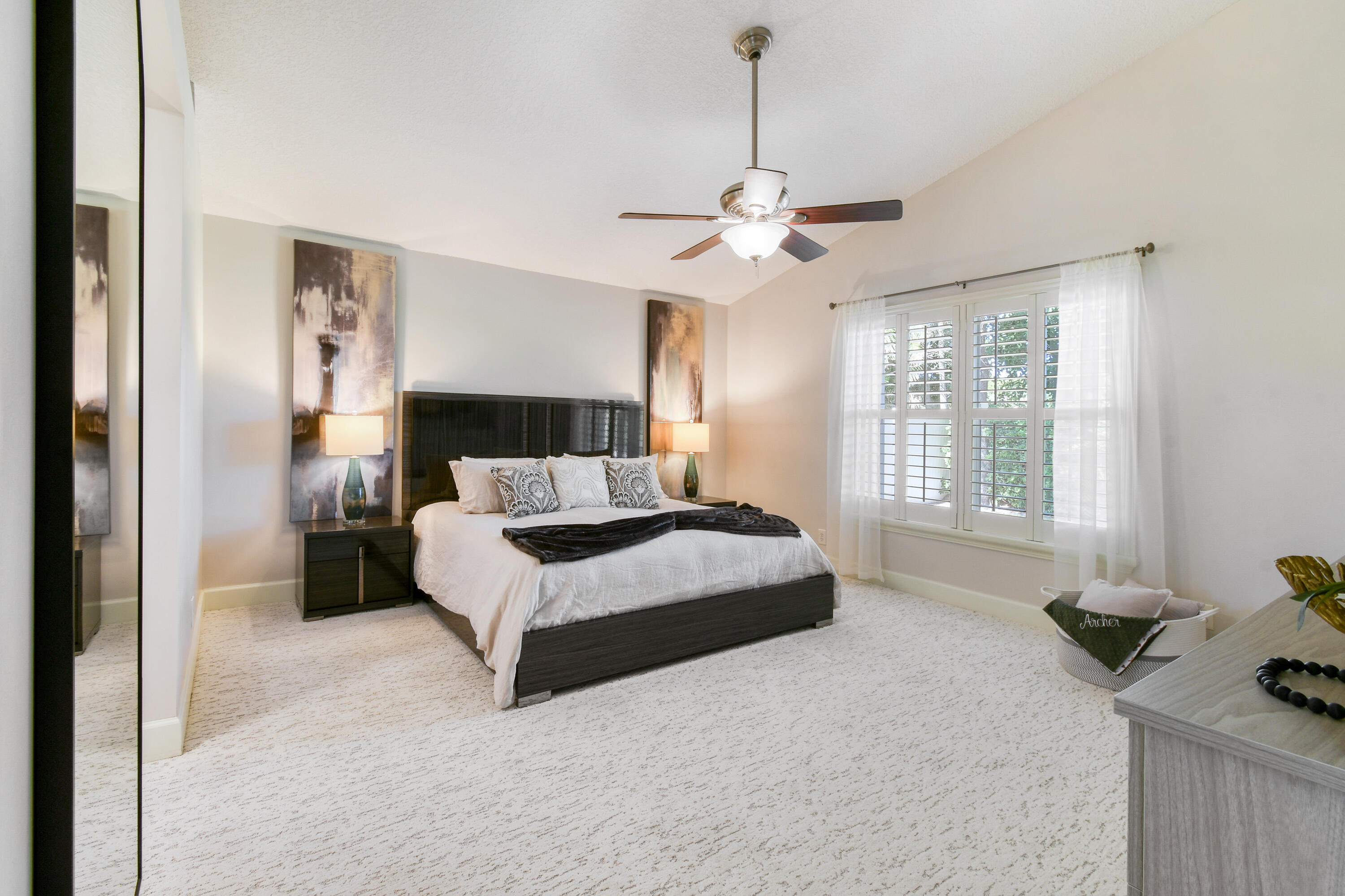 163 Spoonbill Court Jupiter, FL 33458 - Photo 29 of 67 a spacious bedroom with a bed and a chandelier