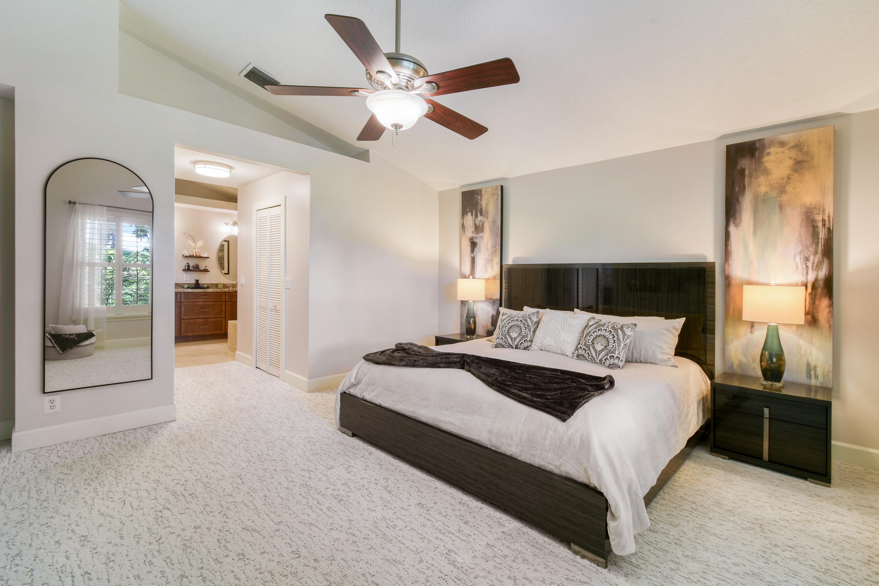 163 Spoonbill Court Jupiter, FL 33458 - Photo 30 of 67 a spacious bedroom with a bed and a large mirror
