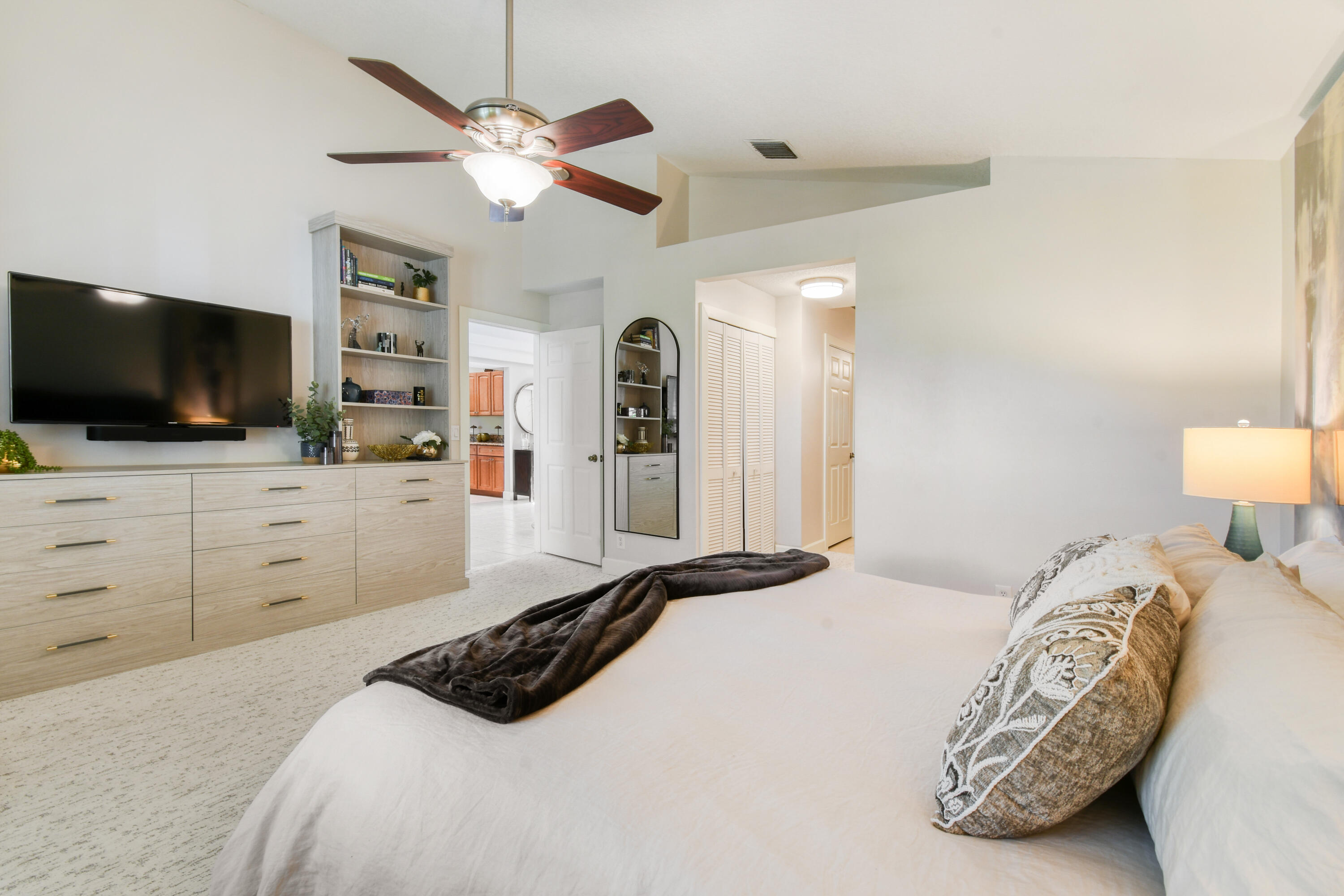 163 Spoonbill Court Jupiter, FL 33458 - Photo 31 of 67 a bedroom with a bed and a flat screen tv