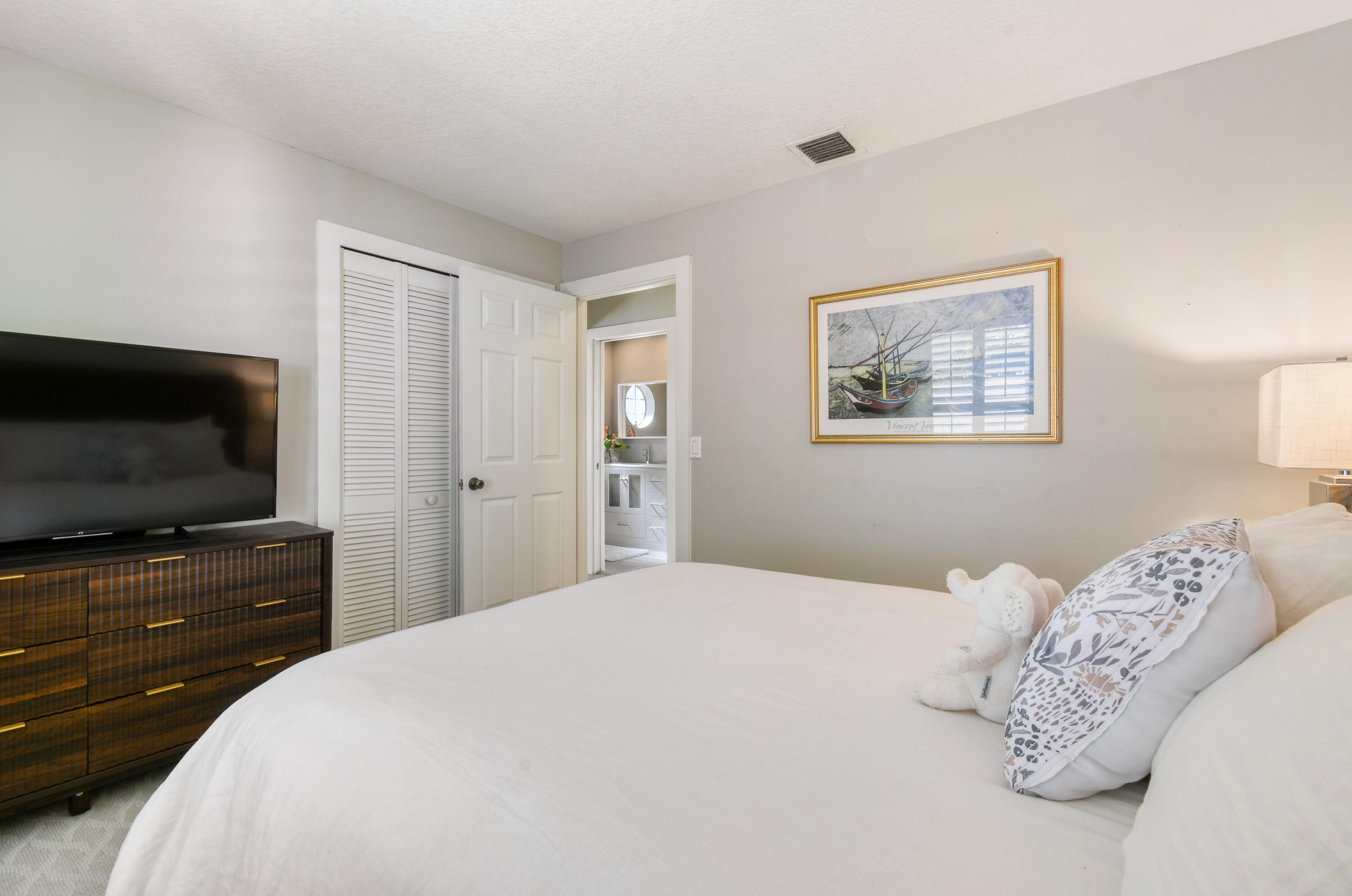 163 Spoonbill Court Jupiter, FL 33458 - Photo 37 of 67 a bedroom with a bed and a flat screen tv