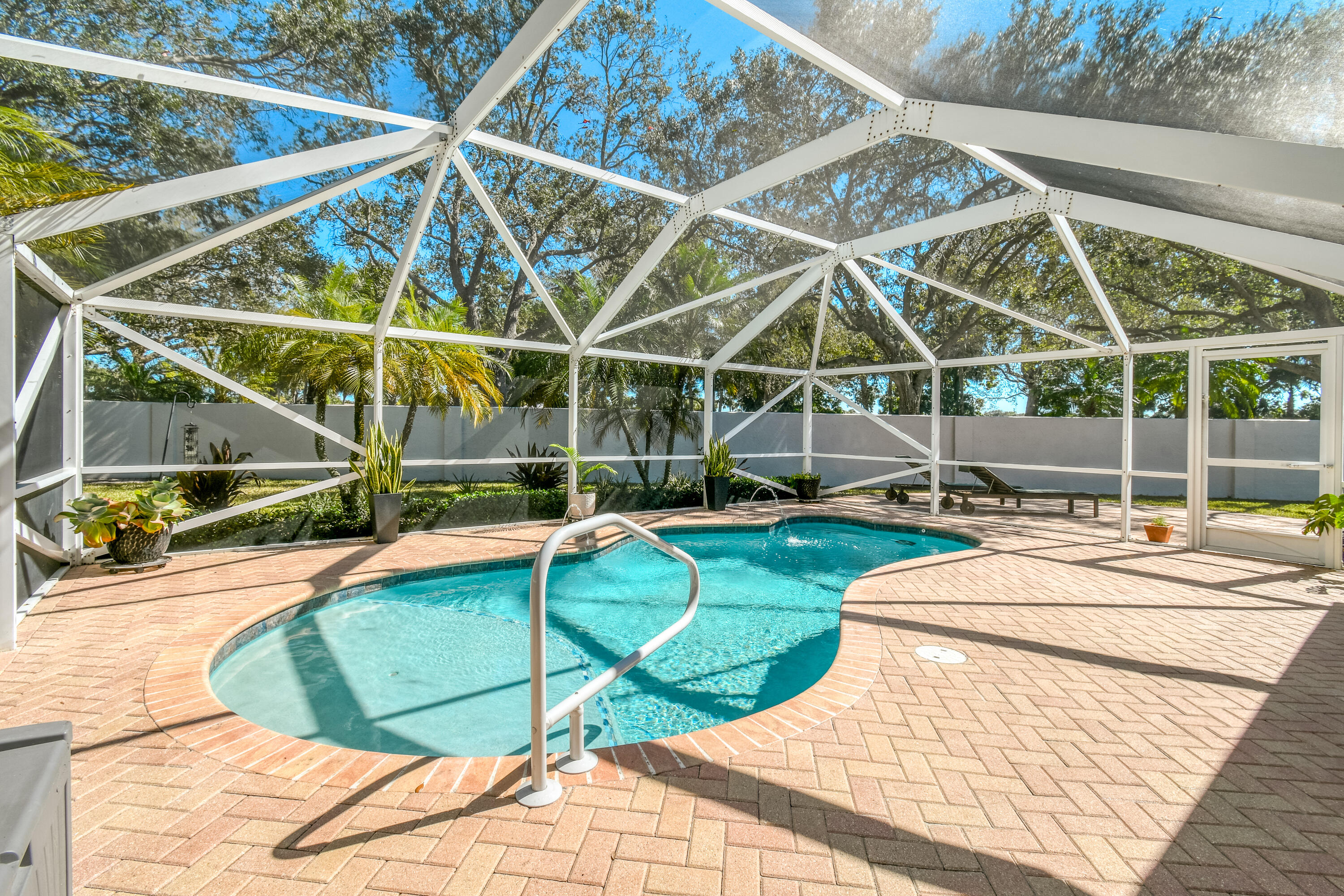 163 Spoonbill Court Jupiter, FL 33458 - Photo 45 of 67 a view of a swimming pool with a patio and yard of the house