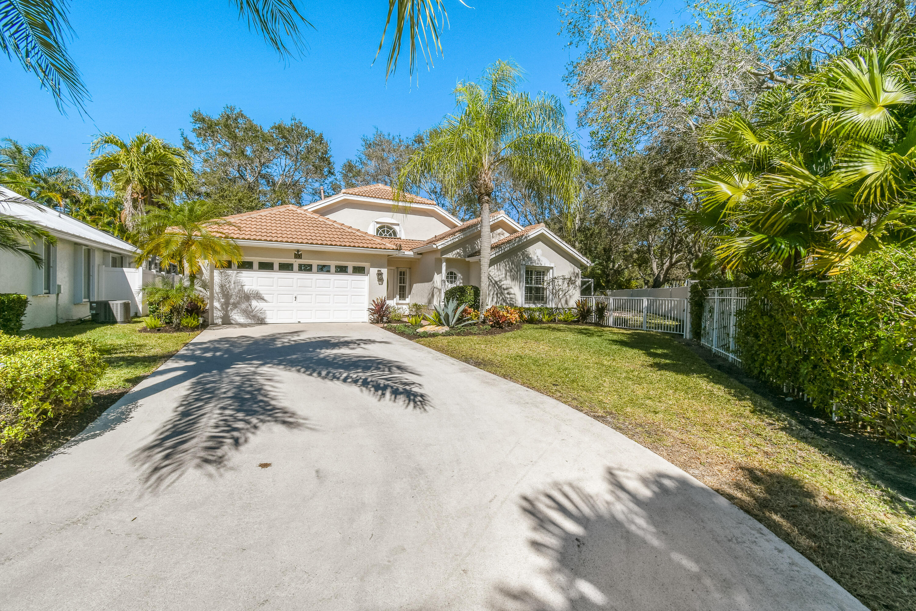 163 Spoonbill Court Jupiter, FL 33458 - Photo 5 of 67 a view of a white house with a big yard and potted plants