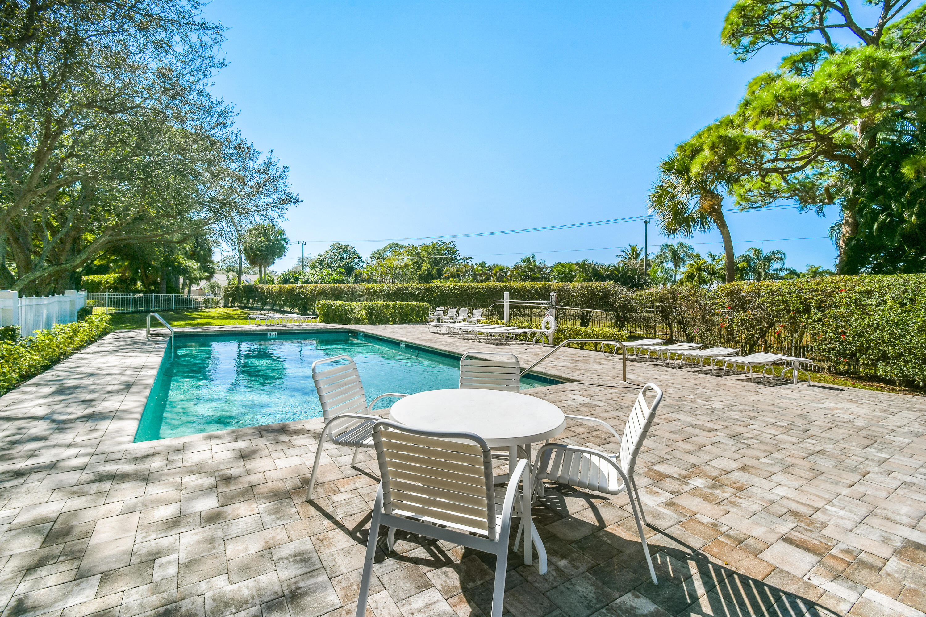 163 Spoonbill Court Jupiter, FL 33458 - Photo 57 of 67 a view of a lake with table and chairs under an umbrella