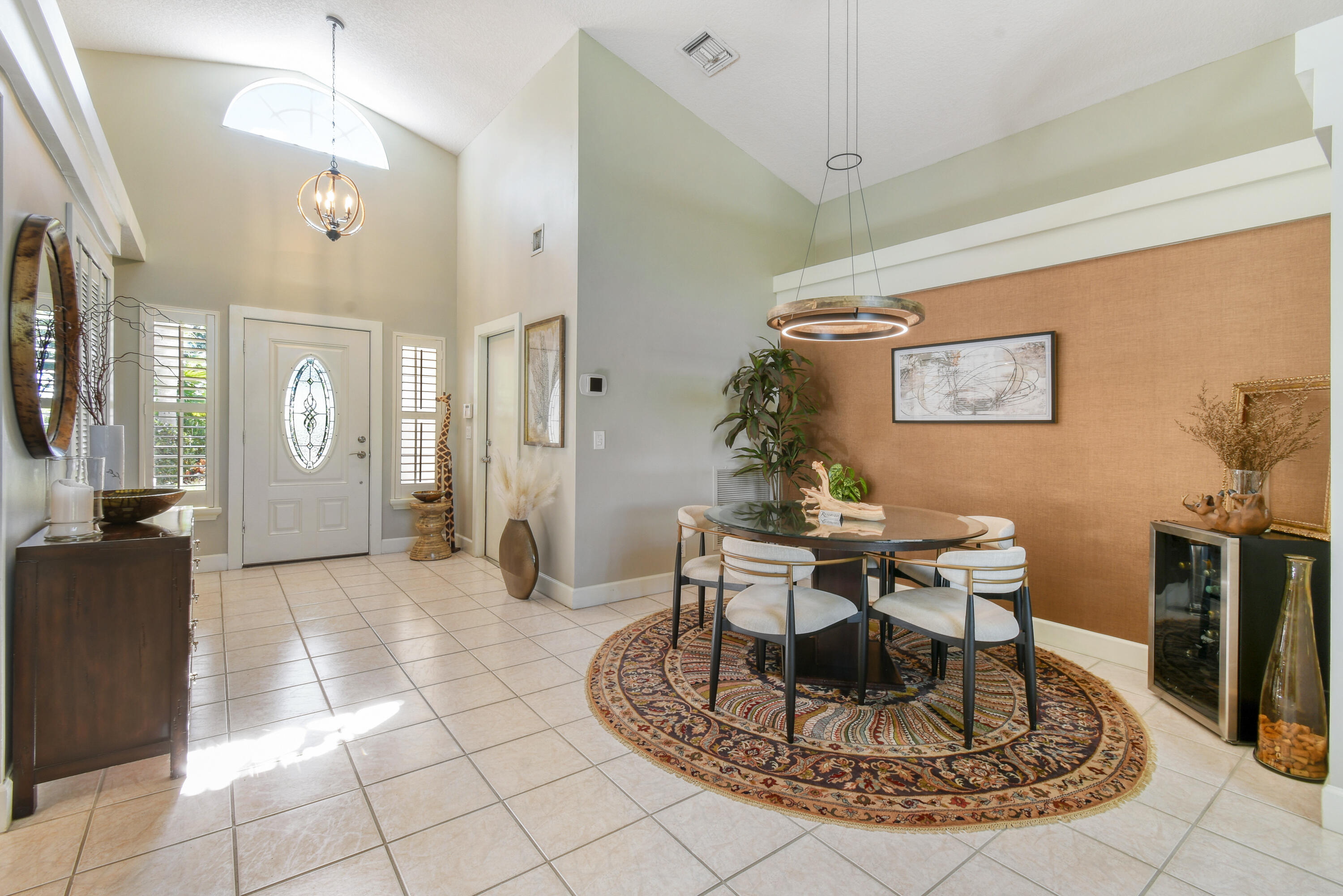 163 Spoonbill Court Jupiter, FL 33458 - Photo 8 of 67 a living room with furniture a dining table and a chandelier