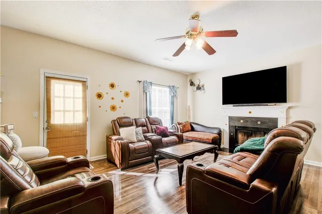 a living room with furniture a flat screen tv and a window