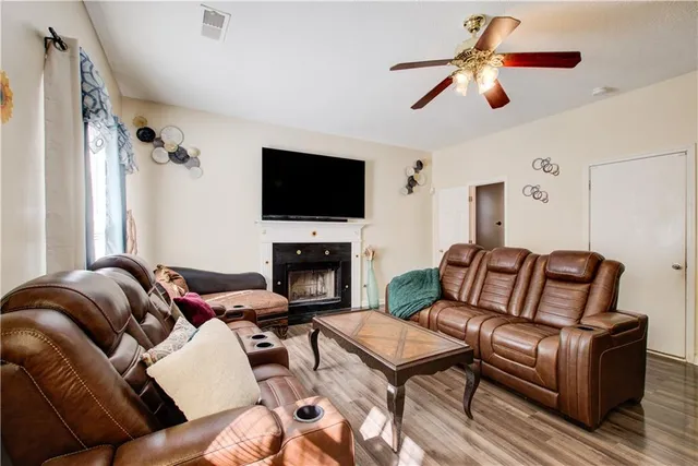 a living room with furniture a flat screen tv and a fireplace