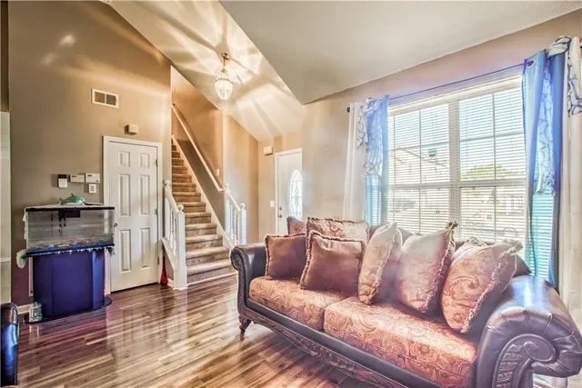 a living room with furniture and a wooden floor
